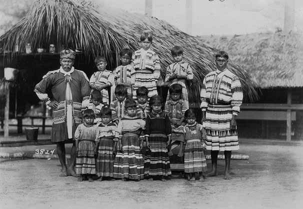 Beginning in the 1910s, Seminoles and Miccosukees divided their time between tourist attraction villages and secluded camps on tree islands in the Everglades and Big Cypress Swamp. This photograph was probably shot at Musa Isle, on the Miami River. December 11, 1923. Photo by Claude Matlack. 90-30
