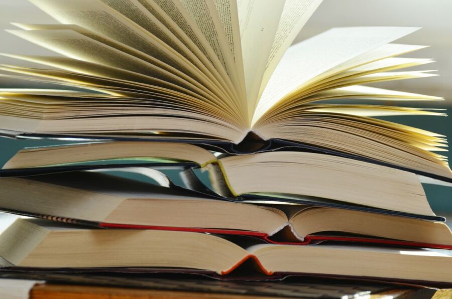 Stack of books. The top book is opened revealing it's pages