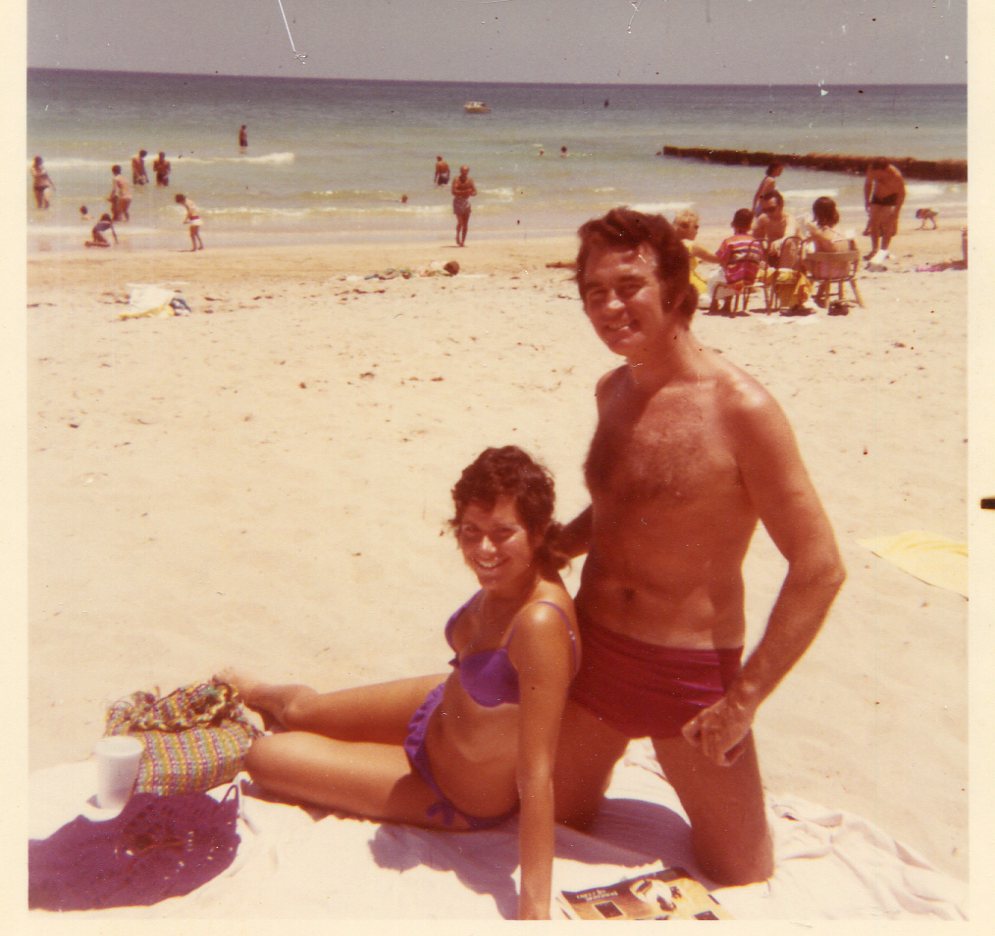 Ruth Aylward sits on the sand and her husband Gus kneels behind her on 64th Street Beach in 1969