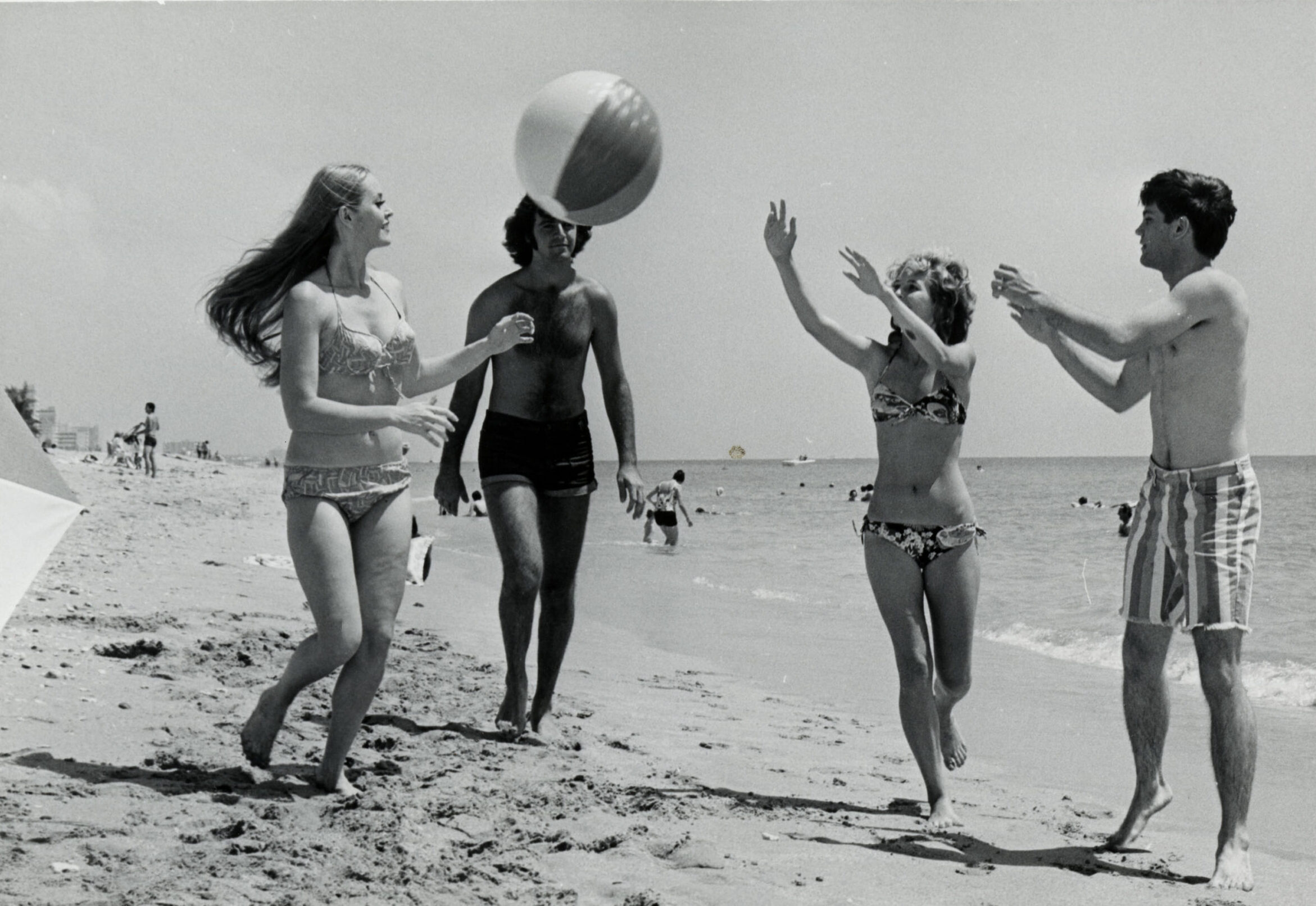 Group of people playing with beach ball at the beach.
