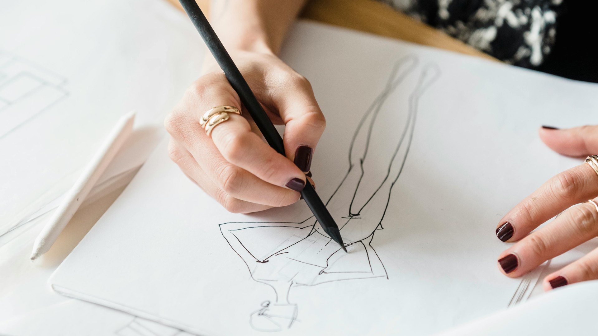 View from above of a person drawing a fashion sketch