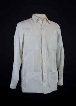 El Encanto guayabera. 1951. Linen. By the mid-20th century, the guayabera with two chest pockets and two hem pockets was in common use in Havana, Cuba, though the specifics of the historical development of this style of guayabera are unclear. Havana clothing stores, including the legendary El Encanto department store, carried the shirt, which was sold year round, and advertised during the summer months. Collection of Museum of Miami. Gift of the Association of Former Employees of El Encanto.