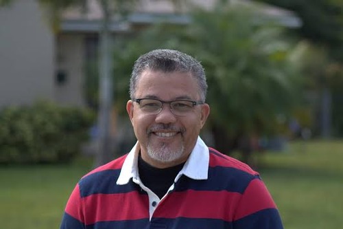 A close-up photo of a man smiling in the outdoors.
